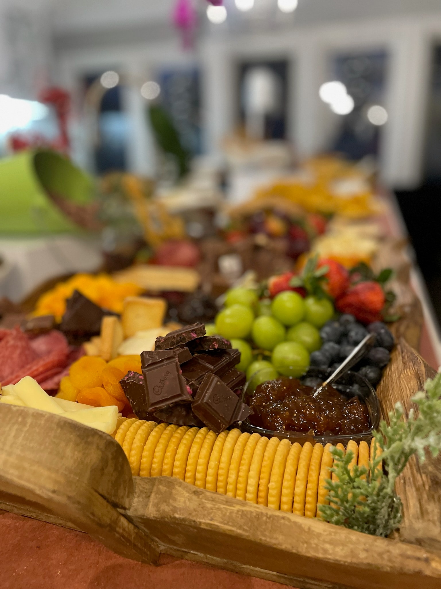 Elegantly styled charcuterie and cheese board with florals, fruits, and artisan meats